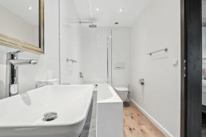 a white bathroom with a tub and a sink at Chalet Bodenschatz in Vandans +48 photos