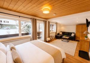 a bedroom with a large bed and a couch at Chalet Bodenschatz in Vandans