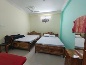 a room with two twin beds and a chair at Mayur Lodge And Restaurant in Khejuria Ghāt