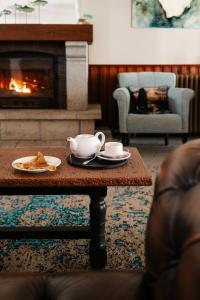a coffee table with a tea set on it in front of a fireplace at Auberge du Cabestan Hotel Audierne in Audierne +40 photos