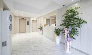 a hallway with two potted plants in a building at Hey, Jecheon Hotel in Chech'ŏn-yŏk