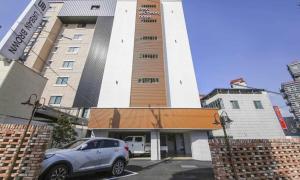 a car parked in a parking lot in front of a building at Hey, Jecheon Hotel in Chech'ŏn-yŏk