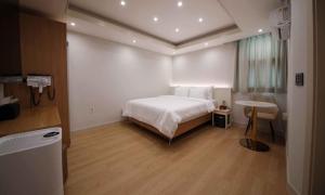 a bedroom with a bed and a table in it at Hey, Jecheon Hotel in Chech'ŏn-yŏk +50 photos