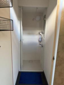 a walk in shower with a blue rug in a bathroom at HANA88のa,b in Otsu +25 photos