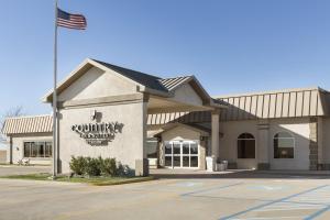 a building with an american flag in front of it at Country Inn & Suites by Radisson, Sidney, NE in Sidney