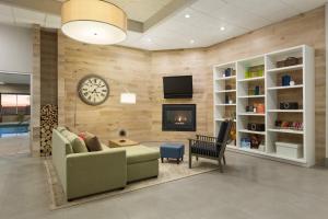 a living room with a couch and a clock on a wall at Country Inn & Suites by Radisson, Sidney, NE in Sidney