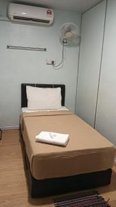 a bed in a room with a fan at SC Lodging Sinsuran Complex in Kota Kinabalu