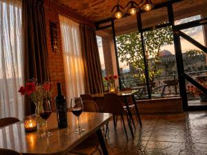 a dining room with a table with glasses of wine at Panorama RABATI in Akhaltsikhe