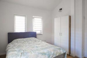 a bedroom with a bed and a white cabinet at AG Apartmans in Gornji Vakuf