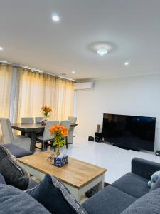 a living room with couches and a large screen tv at The Quiet Stay in Wyndham Vale