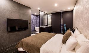 a hotel room with a bed and a bathroom at Hotel The May in Namyangju