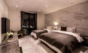 a hotel room with two beds and a wall mural at Hotel The May in Namyangju
