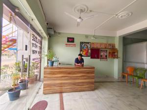 a man sitting at the counter of a restaurant at Mayur Lodge And Restaurant in Khejuria Ghāt