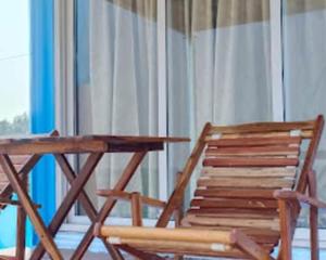 a wooden table and a chair next to a window at Sapphire Inn in Chennai