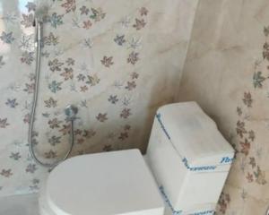 a bathroom with a toilet in a room at Sapphire Inn in Chennai