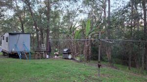 a trailer and a grill in a yard with trees at Truck Caravan Rustic Sunflower in Mount Crosby