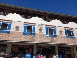 a building with blue windows on the side of it at JM-RN Pensione House in Padre Burgos