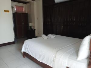 a bedroom with a large bed with white sheets and pillows at JM-RN Pensione House in Padre Burgos