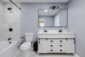 a white bathroom with a sink and a mirror at Large 3 bed 2 bath home in Mobile +18 photos