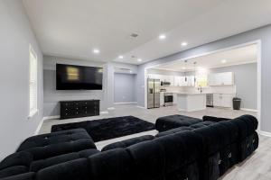 a living room with a black couch and a kitchen at Large 3 bed 2 bath home in Mobile