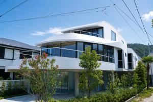a white house with glass windows at 利々 葉山 lili villa hayama in Hayama