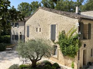 a stone building with a table and a tree at Moulin de Carrière, dans un parc de 2 hectares à Uzès in Uzès