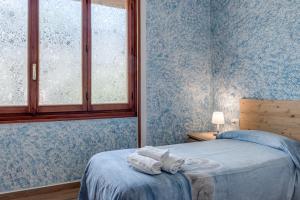 a bedroom with a bed with blue walls and a window at Guest House Fantaccini con Piscina in Pelago +20 photos