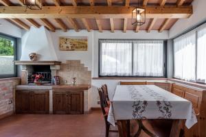 a kitchen with a table and chairs and windows at Guest House Fantaccini con Piscina in Pelago