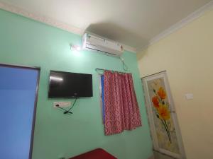 a room with a flat screen tv on the wall at Mayur Lodge And Restaurant in Khejuria Ghāt