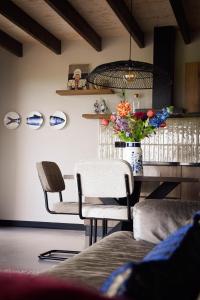 a room with a table with chairs and a vase of flowers at De Tulpenhoeve in Spakenburg