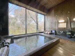 a large swimming pool with a large window in a bathroom at Nagataki in Nakatsugawa
