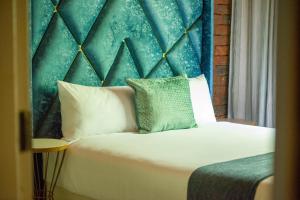 a bedroom with a large bed with a blue headboard at Kneizenberg Boutique Lodge & Spa in Louis Trichardt