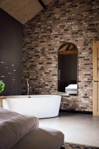 a bathroom with a bath tub and a mirror at De Tulpenhoeve in Spakenburg