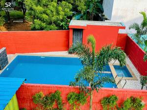 a swimming pool next to a red fence with at sky suite residency in Auroville