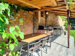 a wooden table and chairs under a brick wall at Casa Roxana in Pangarati