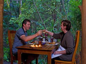 a man and a woman sitting at a table at Wollumbin Palms Rainforest Retreat in Uki