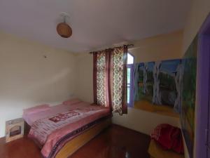 a small bedroom with a bed and a window at Nirvana Stays and Cafe in Manāli +7 photos