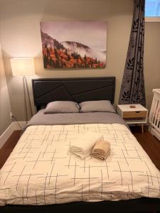 a bedroom with a bed with two towels on it at Bright New 2BR Suite Near YVR in Vancouver