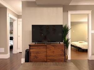 a living room with a flat screen tv on a dresser at Bright New 2BR Suite Near YVR in Vancouver