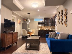 a living room with a blue couch and a kitchen at Bright New 2BR Suite Near YVR in Vancouver
