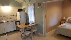una pequeña cocina con una cama y una mesa en una habitación en Magda en Villa La Angostura