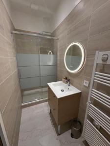 a bathroom with a sink and a shower and a mirror at Chez Rémi in Écommoy