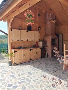 a kitchen in a wooden building with a sink at David House Piscina incalzita si jacuzzi in Pietrari