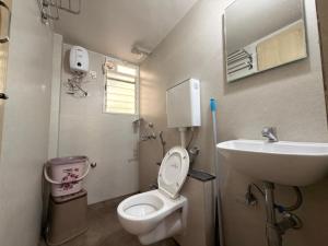 a small bathroom with a toilet and a sink at My second home at Nashik in Nashik +25 photos