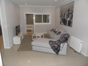 ein Wohnzimmer mit einem weißen Sofa und einem TV in der Unterkunft Porto In in Porto