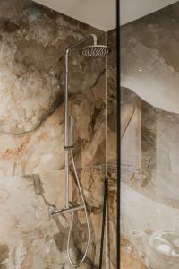 a shower in a bathroom with a stone wall at De Tulpenhoeve in Spakenburg +33 photos