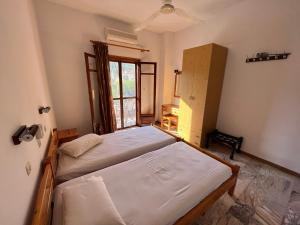 a bedroom with two beds and a window at Poseidonio Apartments in Poseidónion