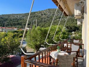 a balcony with a table and chairs and a mountain at Poseidonio Apartments in Poseidónion