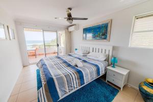 a bedroom with a bed and a view of the ocean at Samarinda Jewel by the Sea in Point Lookout +82 photos