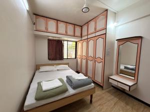 a small bedroom with a bed and a mirror at My second home at Nashik in Nashik